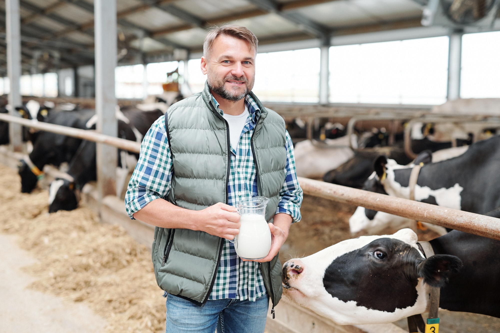 happy-young-worker-of-dairy-farm-holding-jug-with-fresh-milk.jpg